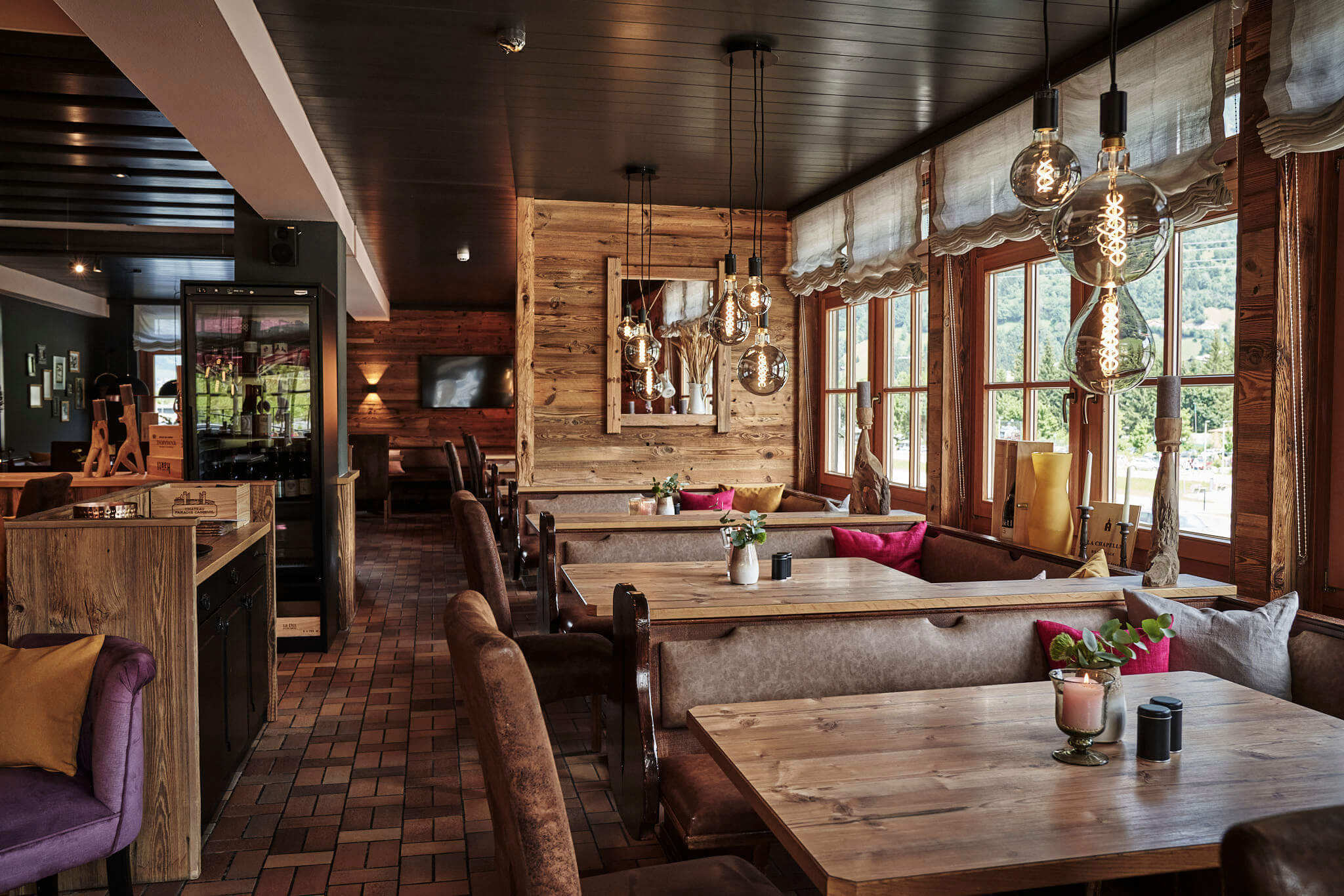 Gemütliches Restaurant im Vintage-Look mit Holzdetails und großen Fenstern.