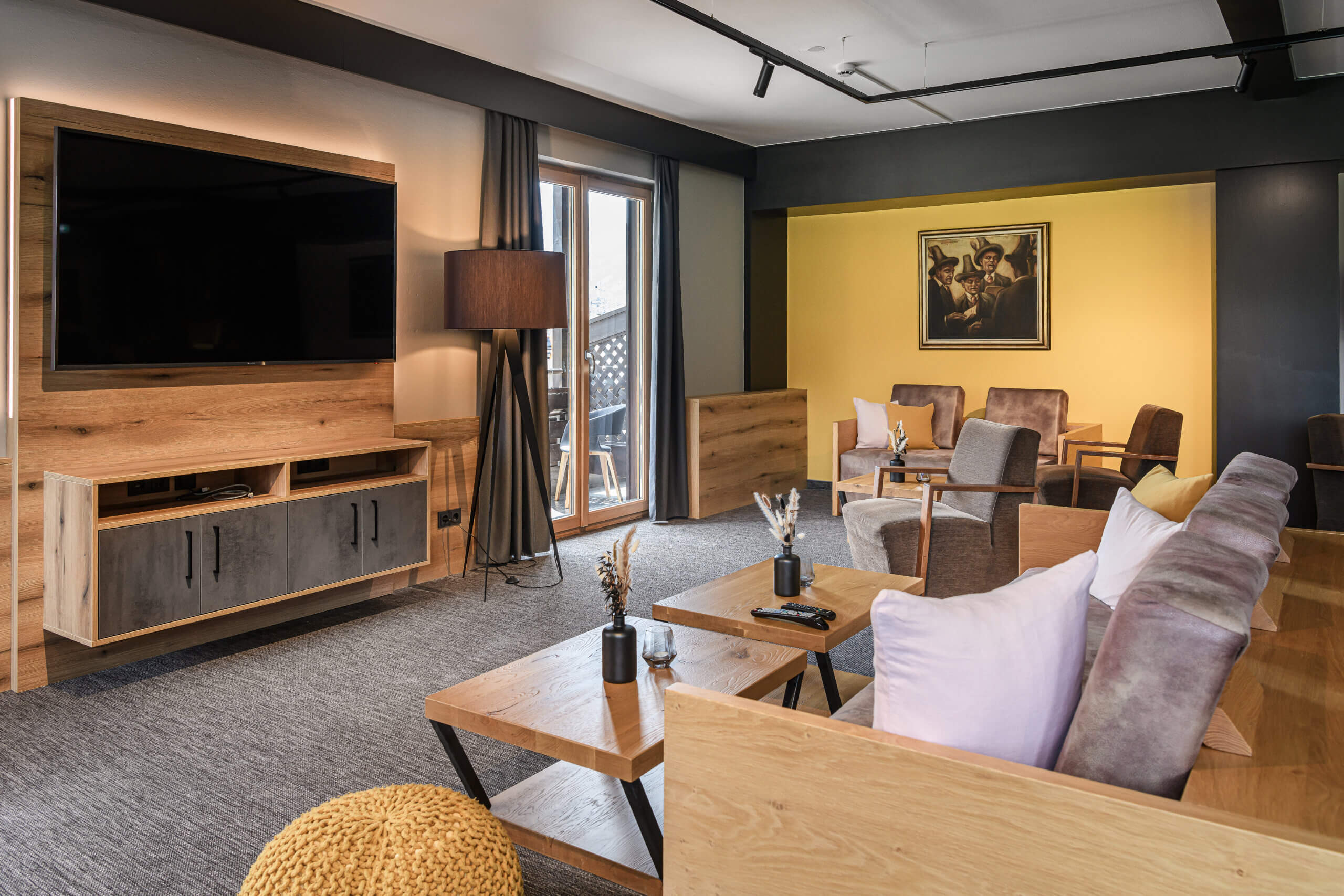 Moderne Lounge im B&B Berglift mit Vintage-Möbeln und Fernseher, einladende Atmosphäre.