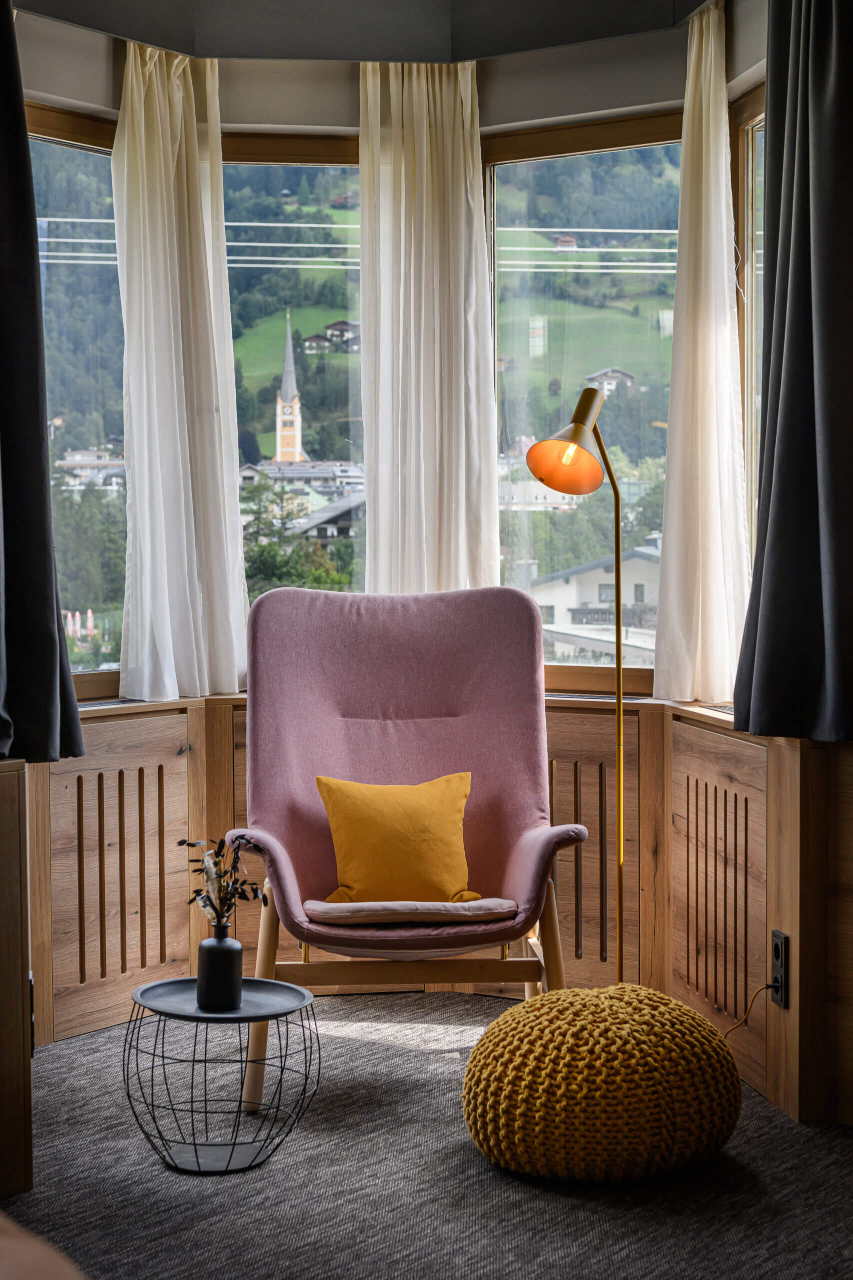Gemütlicher Sitzbereich mit Vintage-Stuhl, Kissen und Blick auf Bad Hofgastein.