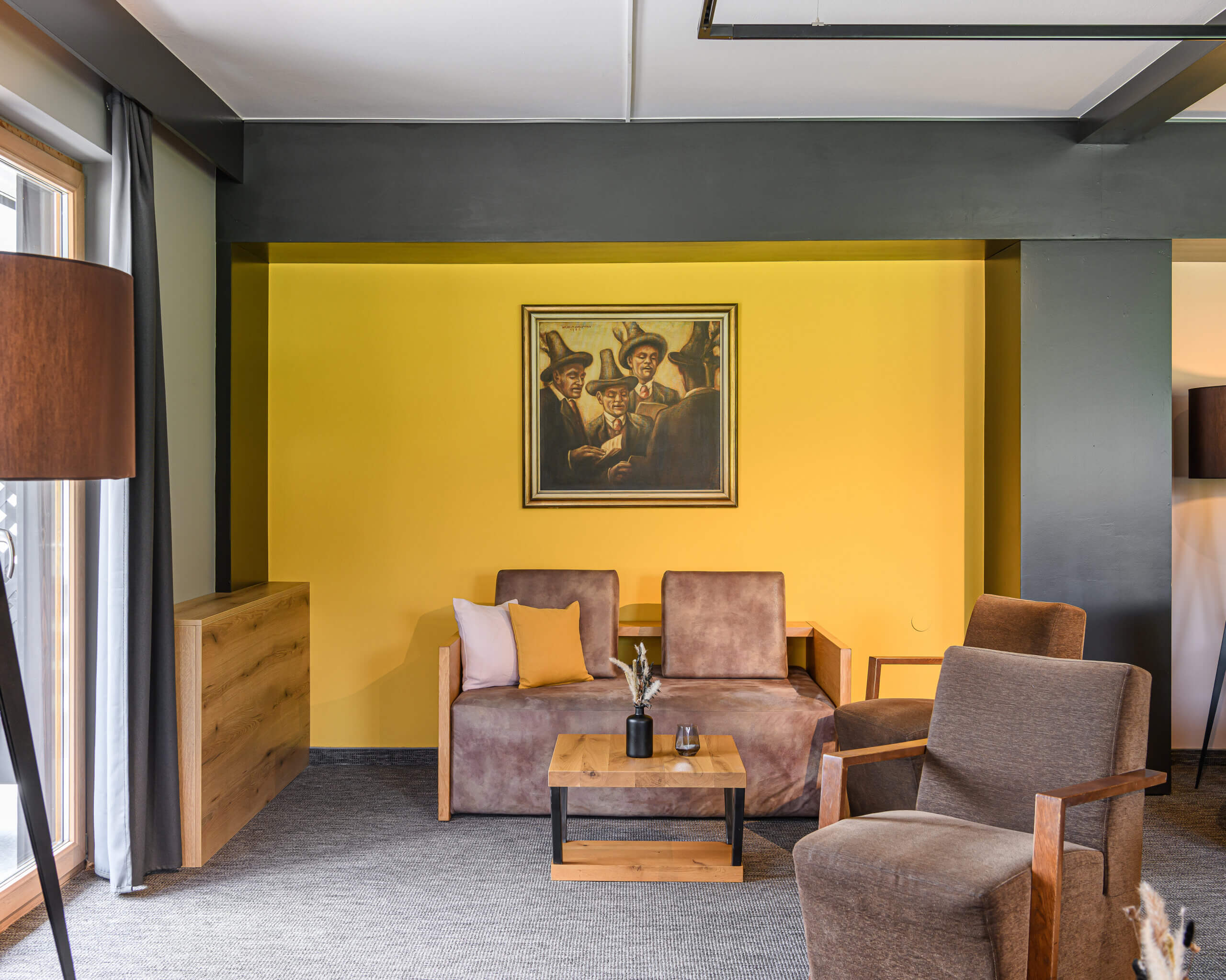 Gemütlicher Lounge-Bereich mit Vintage-Möbeln und gelber Wand im B&B Berglift.