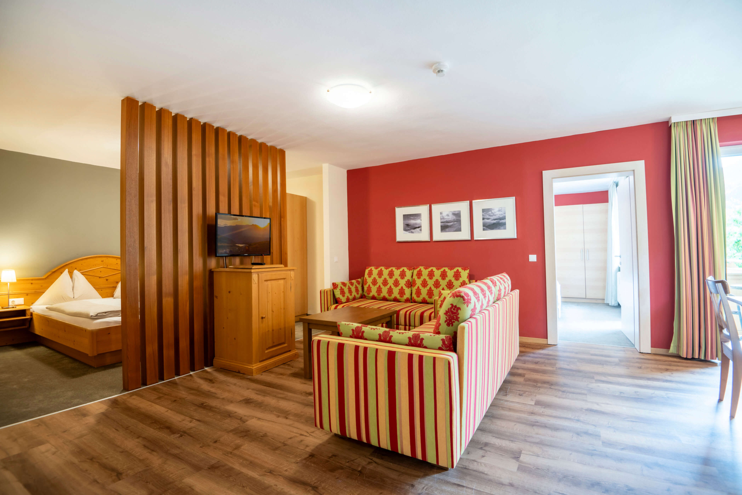 Gemütliches Zimmer im Vintage-Look mit Sofa, TV und separatem Schlafbereich im B&B Berglift.