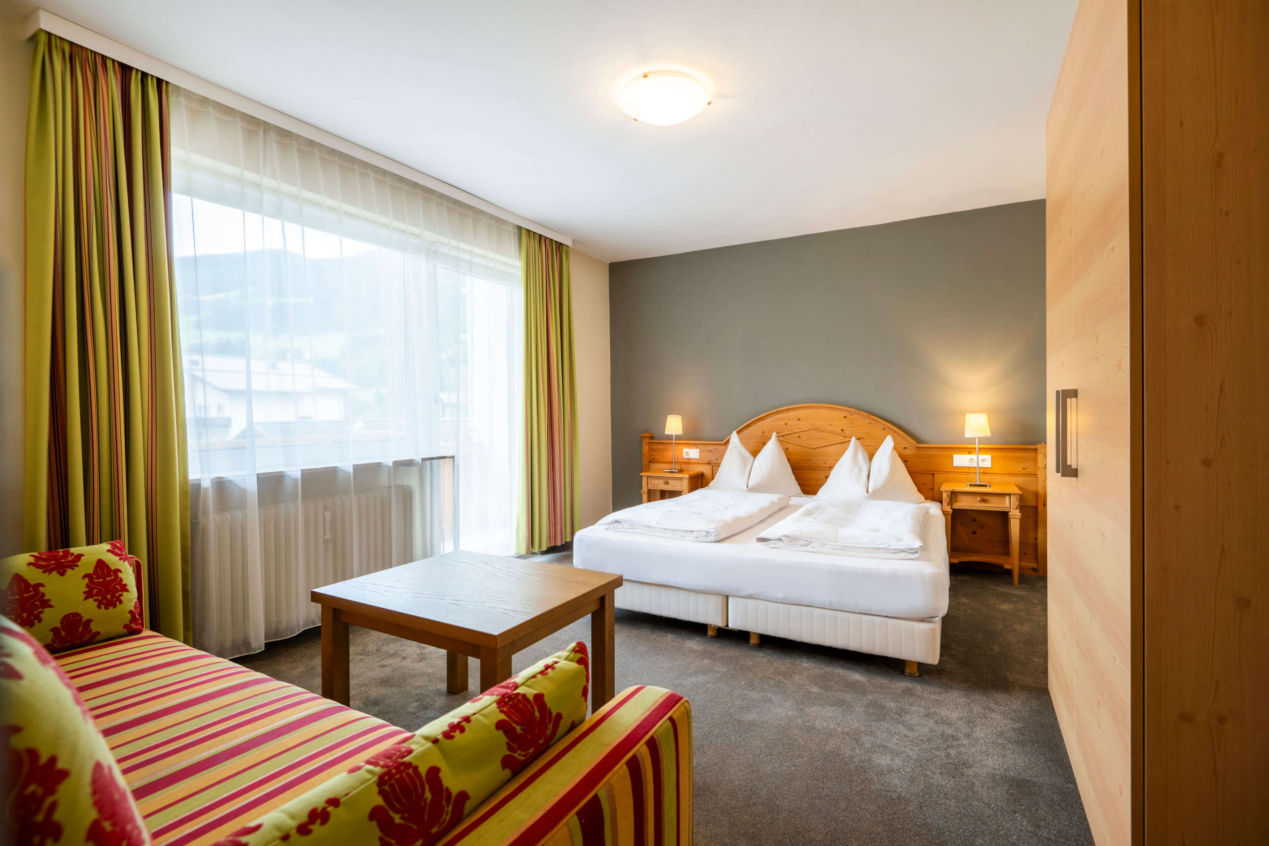 Gemütliches Zimmer im Vintage-Look mit Doppelbett und Wohnbereich in Bad Hofgastein.