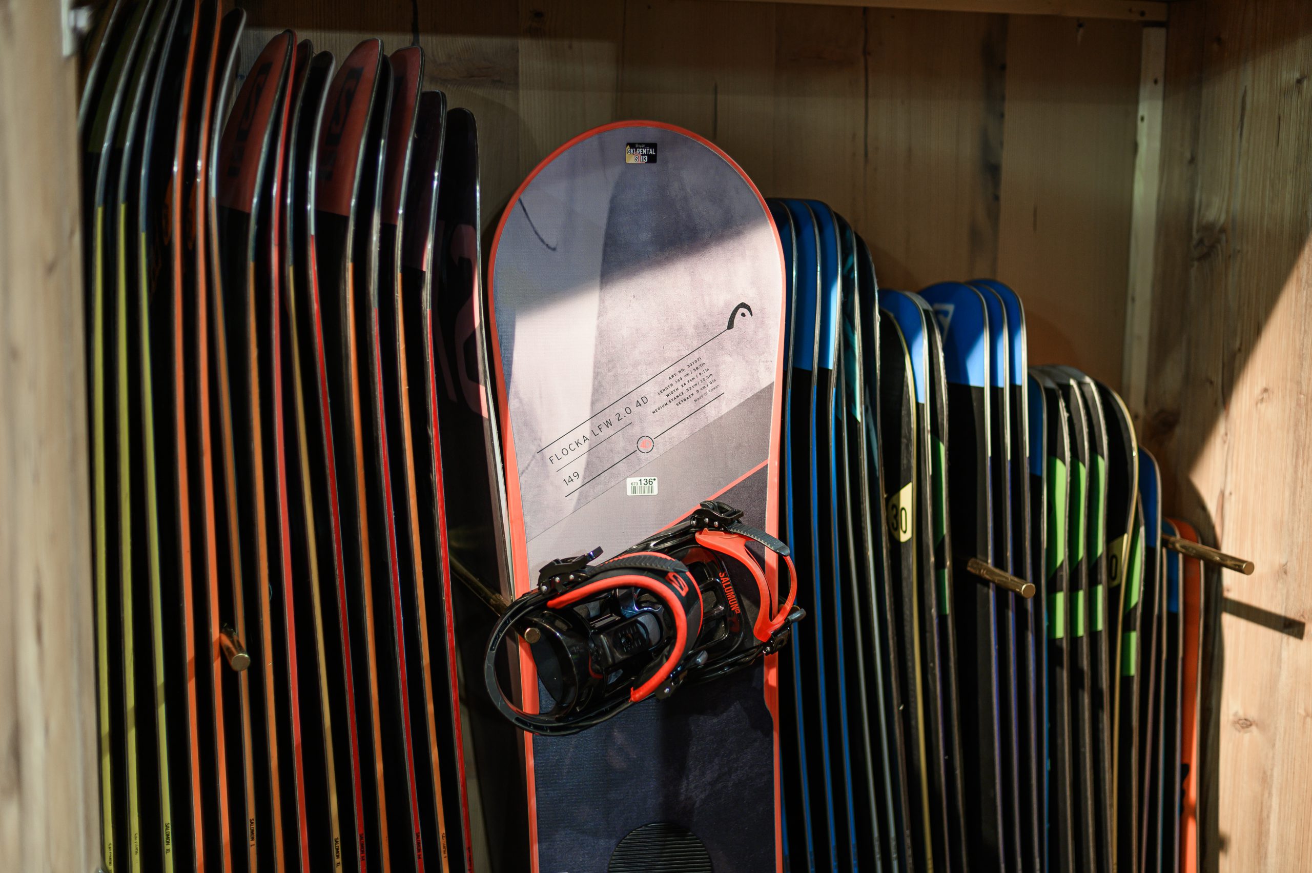 Snowboards in Holzregal im Skiverleih aufgereiht