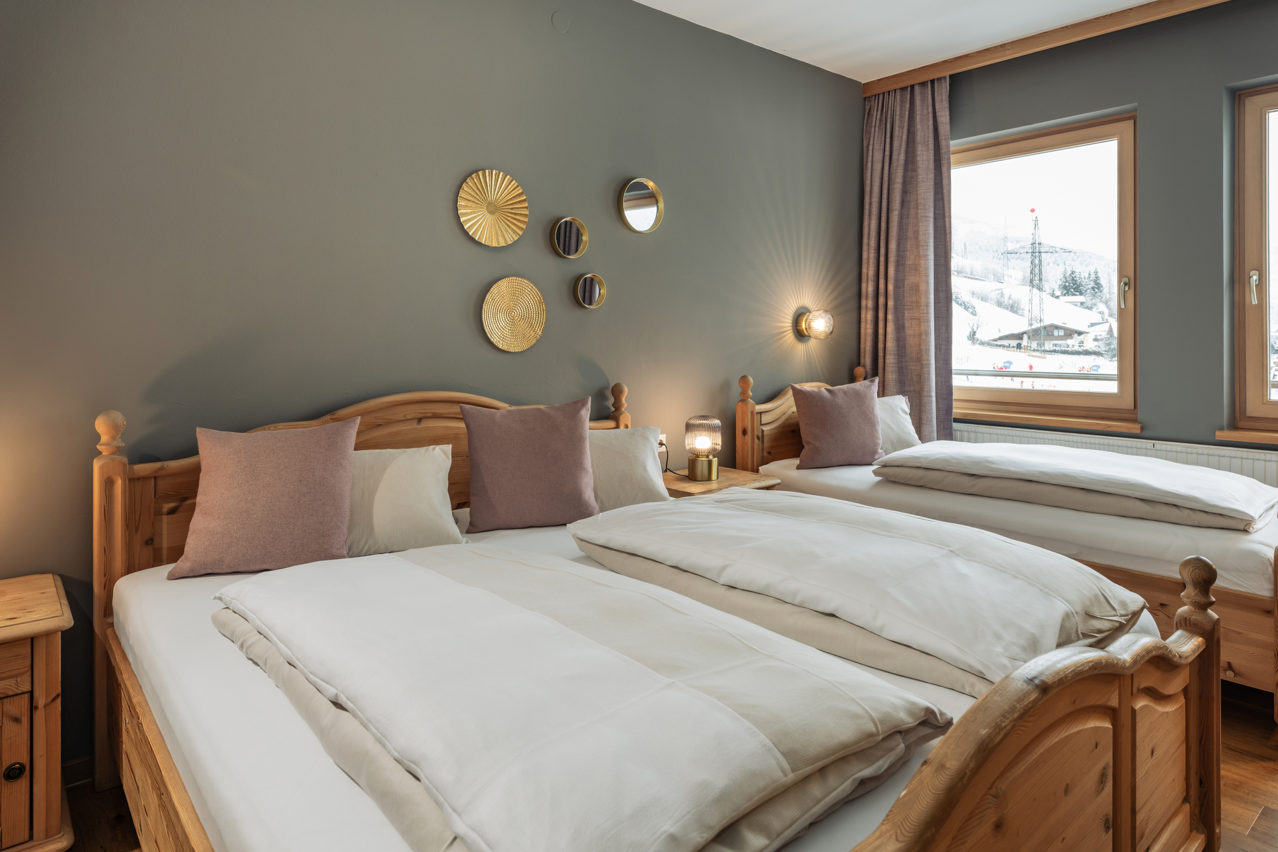 Dreibettzimmer mit Doppelbett, Einzelbett und Blick auf verschneite Berge