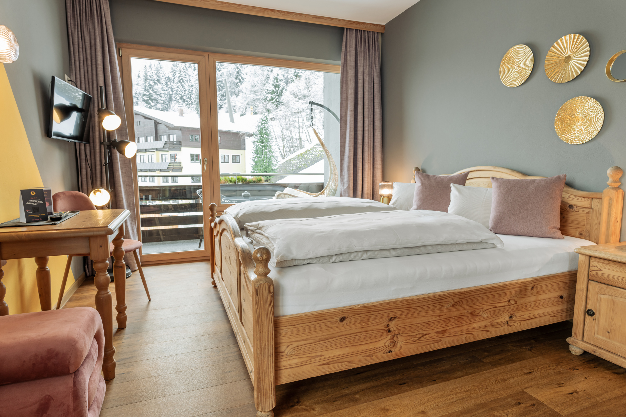 Doppelzimmer mit Holzbett, Balkon und Blick auf verschneite Bäume