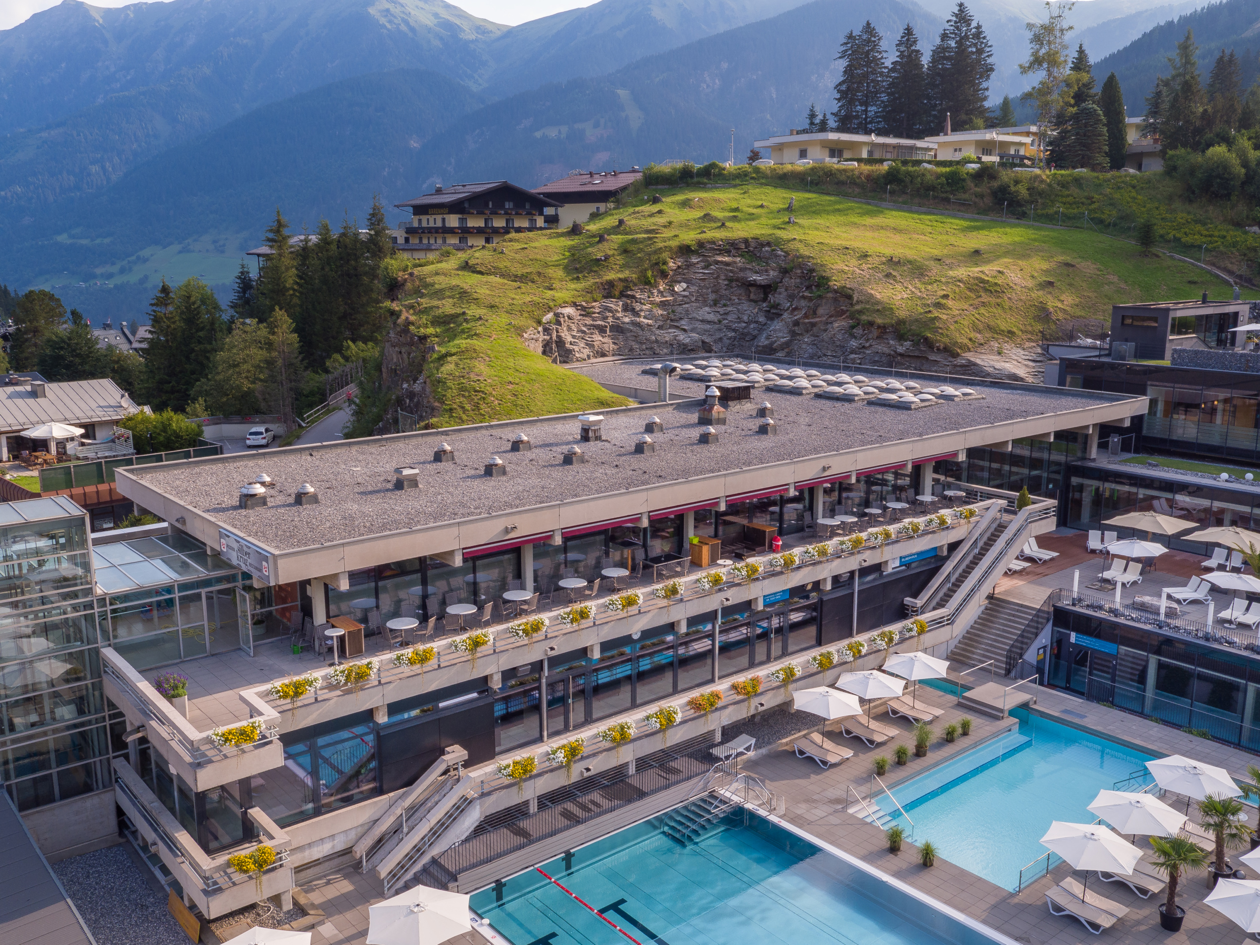 Außenbereich der Felsentherme Bad Gastein mit mehreren Becken, Sonnenterrassen und Bergpanorama